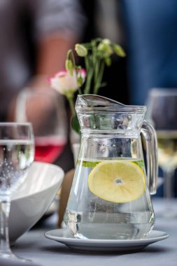 Döşeme kavramı masa. Masada bir sürahi su ve limon ile duruyor. Arka camlar.