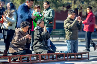 Beijing, Çin - 10 Mart 2016: Tapanların tütsü sopa tutun ve Pekin, Çin Yonghegong Lama Tapınağı'nda dua.