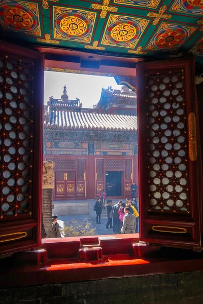 2016 を通じて 雍和宮ラマ教寺院ウィンドウを歩く観光客を見ることができます — ストック写真