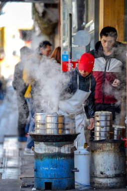 Beijing, Çin - 10 Mart 2016: Tüccar doğrudan sokakta geçen gözlerinin önünde yemek.