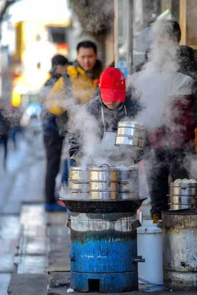 Beijing, Çin - 10 Mart 2016: Tüccar doğrudan sokakta geçen gözlerinin önünde yemek.