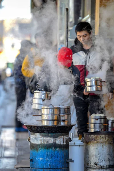 Beijing, Çin - 10 Mart 2016: Tüccar doğrudan sokakta geçen gözlerinin önünde yemek.