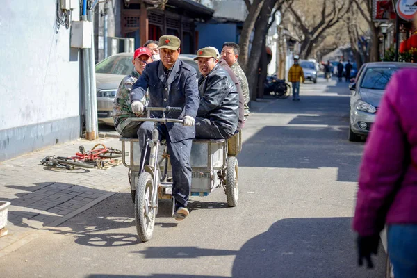 Beijing, Çin - 10 Mart 2016: İnsanlar sokaklarda bisiklet, scooter ve araçların ile ilerliyorsunuz. İnsanlar, ürünler, taşıma motosiklet ile yapı malzemeleri ve çok daha fazlası.