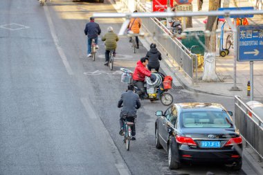 Beijing, Çin - 10 Mart 2016: İnsanlar sokaklarda bisiklet, scooter ve araçların ile ilerliyorsunuz. İnsanlar, ürünler, taşıma motosiklet ile yapı malzemeleri ve çok daha fazlası