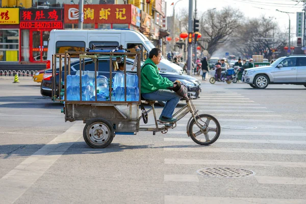 Beijing, Çin - 14 Mart 2016: İnsanlar sokaklarda bisiklet, scooter ve araçların ile ilerliyorsunuz. İnsanlar, ürünler, taşıma motosiklet ile yapı malzemeleri ve çok daha fazlası