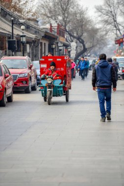 Beijing, Çin - 12 Mart 2016: İnsanlar sokaklarda bisiklet, scooter ve araçların ile ilerliyorsunuz.