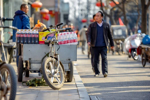 Beijing, Çin - 14 Mart 2016: İnsanlar yürüyüş ve bisiklet, scooter ve araba sokaklarında sürüş.