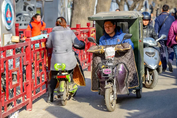 Beijing, Çin - 10 Mart 2016: İnsanlar sokaklarda bisiklet, scooter ve araçların ile ilerliyorsunuz.