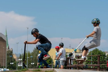 Riga, Letonya - 20 Temmuz 2018: Scooter ile çeşitli hileler skatepark genç yürütmektedir.