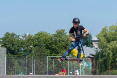 Riga, Letonya - 20 Temmuz 2018: Scooter ile çeşitli hileler skatepark genç yürütmektedir.