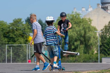 Riga, Letonya - 20 Temmuz 2018: Scooter ile çeşitli hileler skatepark genç yürütmektedir.
