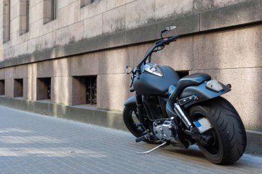 Siyah motosiklet kaldırımda büyük lastikleri ile.