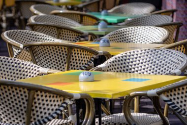 Hasır sandalyeleri ve açık Cafe renkli tablolar.