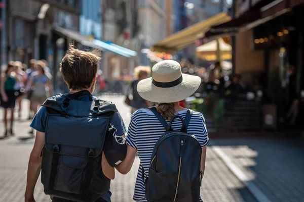 通りを歩いていたバックパックを持つ人々 のカップル 背面から見る — ストック写真