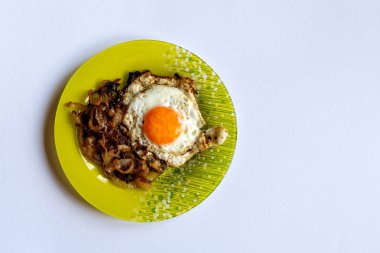 Yeşil plaka sahanda yumurta ve hafif bir arka plan üzerine soğan ile.