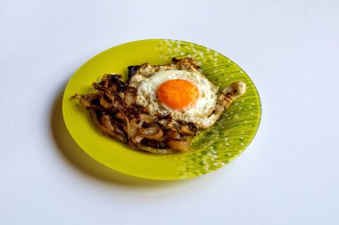 Yeşil plaka sahanda yumurta ve hafif bir arka plan üzerine soğan ile.