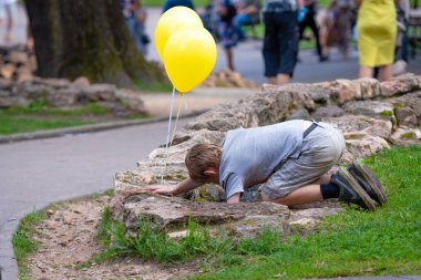 Riga, Letonya - 18 Ağustos 2018: Çocuk elinde balonlarla Şehir Parkı su kanalları çalış.