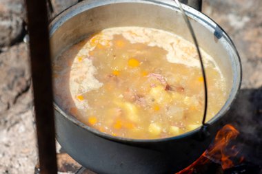 Kamp ateşi üzerinde bir tencerede yemek. Yaz kamp kavramı.