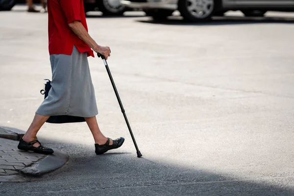 Vanha Nainen Kepin Kanssa Menee Kadun Toiselle Puolelle — kuvapankkivalokuva