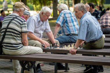 Riga, Letonya - 18 Temmuz 2018: park bankların üzerinde oturan ve satranç oynarken erkekler.