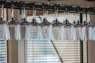 Şarap gözlük bir dizi asmak baş aşağı barda.