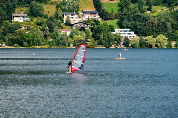 People engaged in active leisure Austrian mountain lake Worthersee.