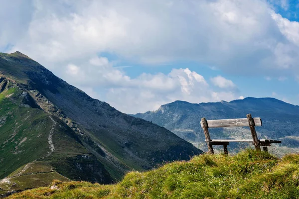 A wooden bench at the top of the Alps, a place for tourists to relax and look at beautiful landscapes.