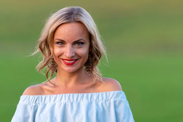 Soft focus photo. A portrait of a young, beautiful blond woman on a green background.