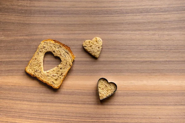 パンとパンから心でハート型のカットです 木製のテクスチャ背景 — ストック写真