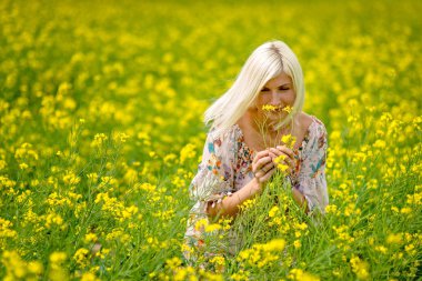 Yumuşak, seçici odak. Sarı çiçek çayır güzel, çekici, sarışın kadın.