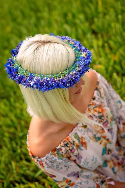 Peygamberçiçeği mavi taç hububat alanındaki güzel, çekici, sarışın kadınla.