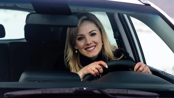 Blond Kobieta Siedzi Biały Samochód Kierownicy Postrzegane Przez Okno — Zdjęcie stockowe