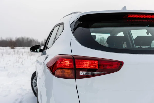 White modern car with lit brake lights. Rear view.