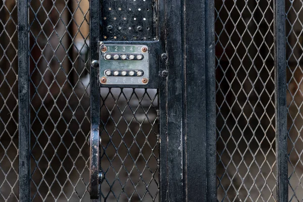 Code lock at the metal yard gate - image