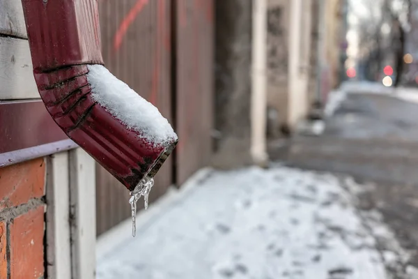 Water Goot Met Ijspegels Onscherpe Straat Achtergrond Afbeelding — Stockfoto