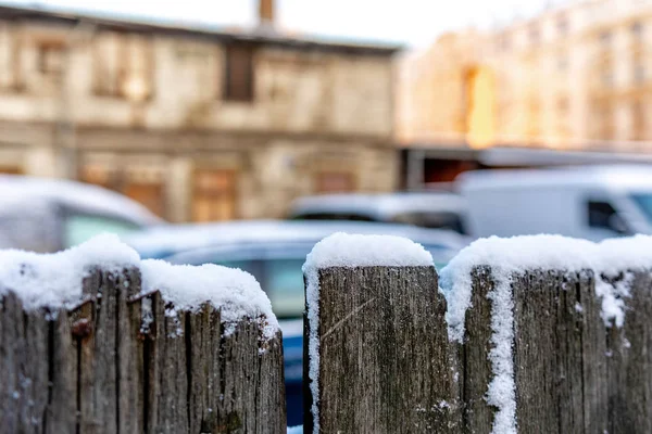 Sneeuw Bedekte Houten Hek Een Achtergrond Wazig Stad Beeld — Stockfoto