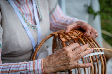 Yaşlı kadın Ulusal kostüm yerel hasır sepet yapmak. Geleneksel el sanatları kavramı. Letonya - görüntü