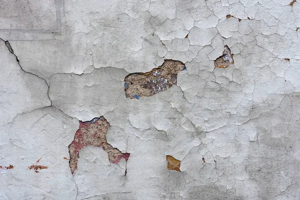 Close-up photo. Fragment of masonry wall cracked decorative plaster.