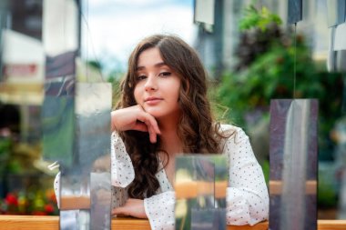 Aynalar kurulumu aracılığıyla genç, sempatik, esmer bir kadın portresi.