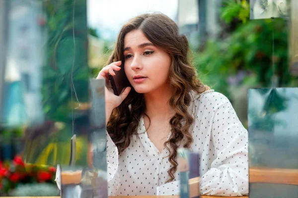 Bir akıllı telefon kullanan bir genç, sempatik, esmer kadın. Bir ayna yüklemesi aracılığıyla bir kadın portresi.