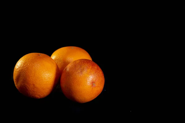 Τρία κόκκινα πορτοκάλια σε μαύρο φόντο - εικόνα — Φωτογραφία Αρχείου