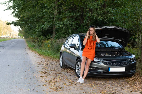 Junge Frau in der Nähe von kaputtem Auto telefoniert und braucht Hilfe — Stockfoto