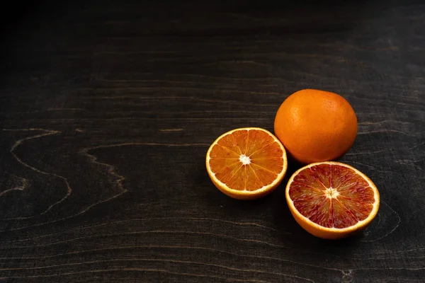 Fotografie pulzujících organických krvavých pomerančů na tmavém pozadí s prostorem pro kopírování. — Stock fotografie