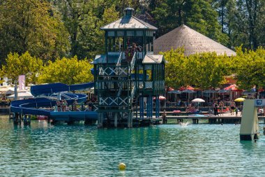 Worthersee, Avusturya - 08 Ağustos 2018: Tekne görünümünden göl ve kıyı şeridi. Yerel halk ve turistler teknelere tarafından tahrik yüzmek ve su eğlence diğer formları kullanmak.