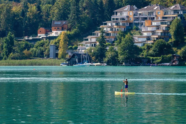 WORTHERSEE, AUSTRIA - 08 AGOSTO 2018: Grandes paisajes desde el barco hasta la orilla del lago, hermosos edificios, montañas, bosques, carreteras . — Foto de Stock