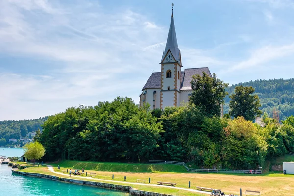 WORTHERSEE, AUSTRIA - 08 de agosto de 2018: Vista del lago Worthersee con la iglesia Maria Worth, Carintia, Austria — Foto de Stock