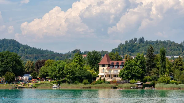 Worthersee, Avusturya - 08 Ağustos 2018: Tekne göl, güzel binalar, Dağları, ormanları, Karayolları sahil hattı büyük sahne. — Stok fotoğraf