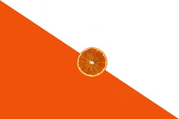 Pose plate de tranches de fruits orange sur fond de papier blanc et orange — Photo