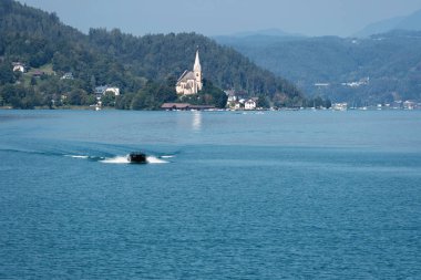 Worthersee, Avusturya - 08 Ağustos 2018: Maria Worth kilise, Carinthia, Avusturya Worthersee Gölü görünümünü