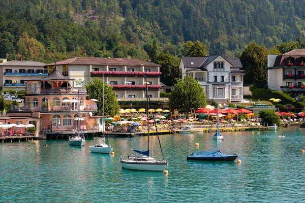 Worthersee, Avusturya - 08 Ağustos 2018: Tekne görünümünden göl ve kıyı şeridi. Yerel halk ve turistler teknelere tarafından tahrik yüzmek ve su eğlence diğer formları kullanmak. — Stok fotoğraf